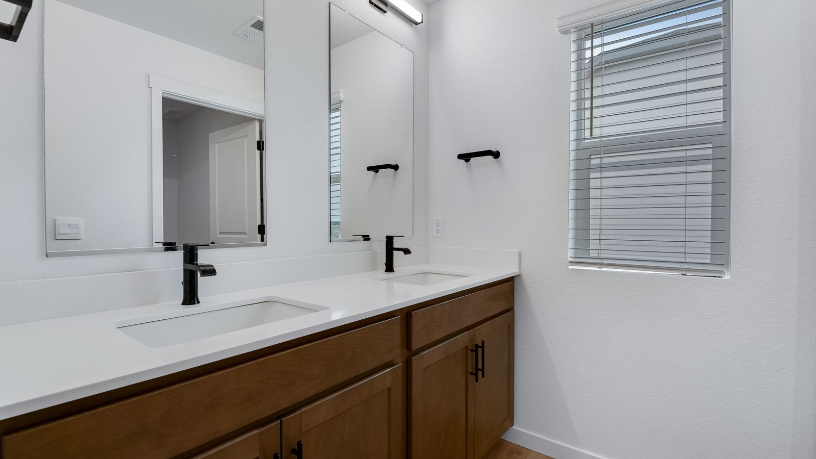 Secondary bathroom with dual vanity sinks in new home at Lakeside Canyon