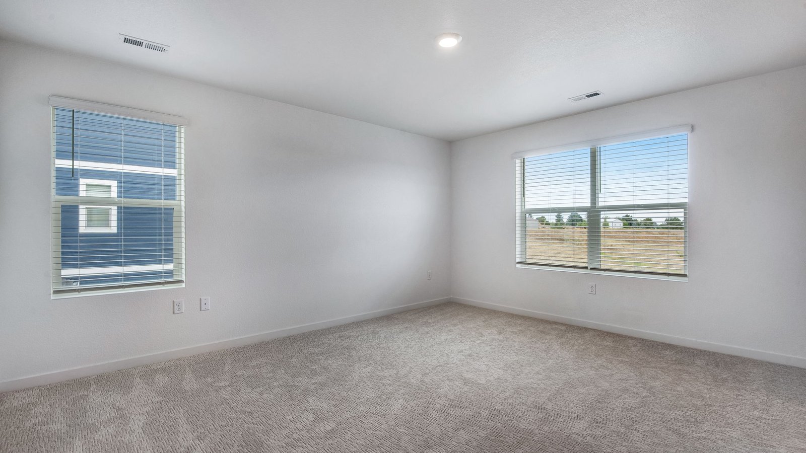 Spacious primary bedroom with large windows in new home at Lakeside Canyon