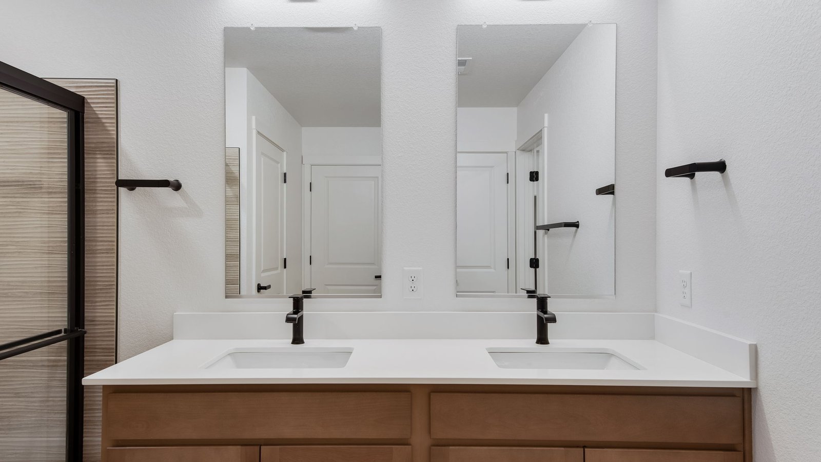 Attached private primary bathroom with dual vanity sinks in new home in Mead Colorado
