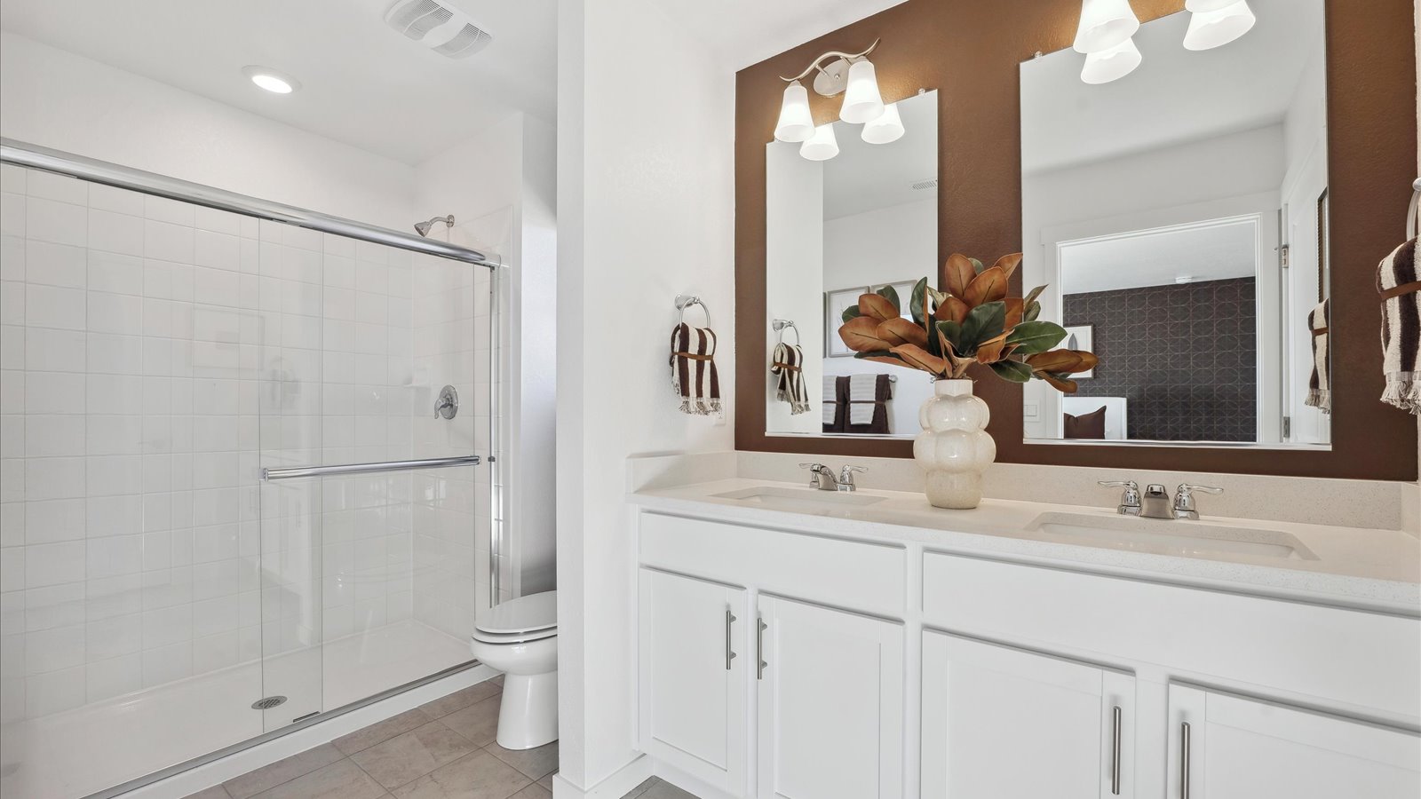Primary bathroom in Muirfield home with dual sinks and walk-in shower