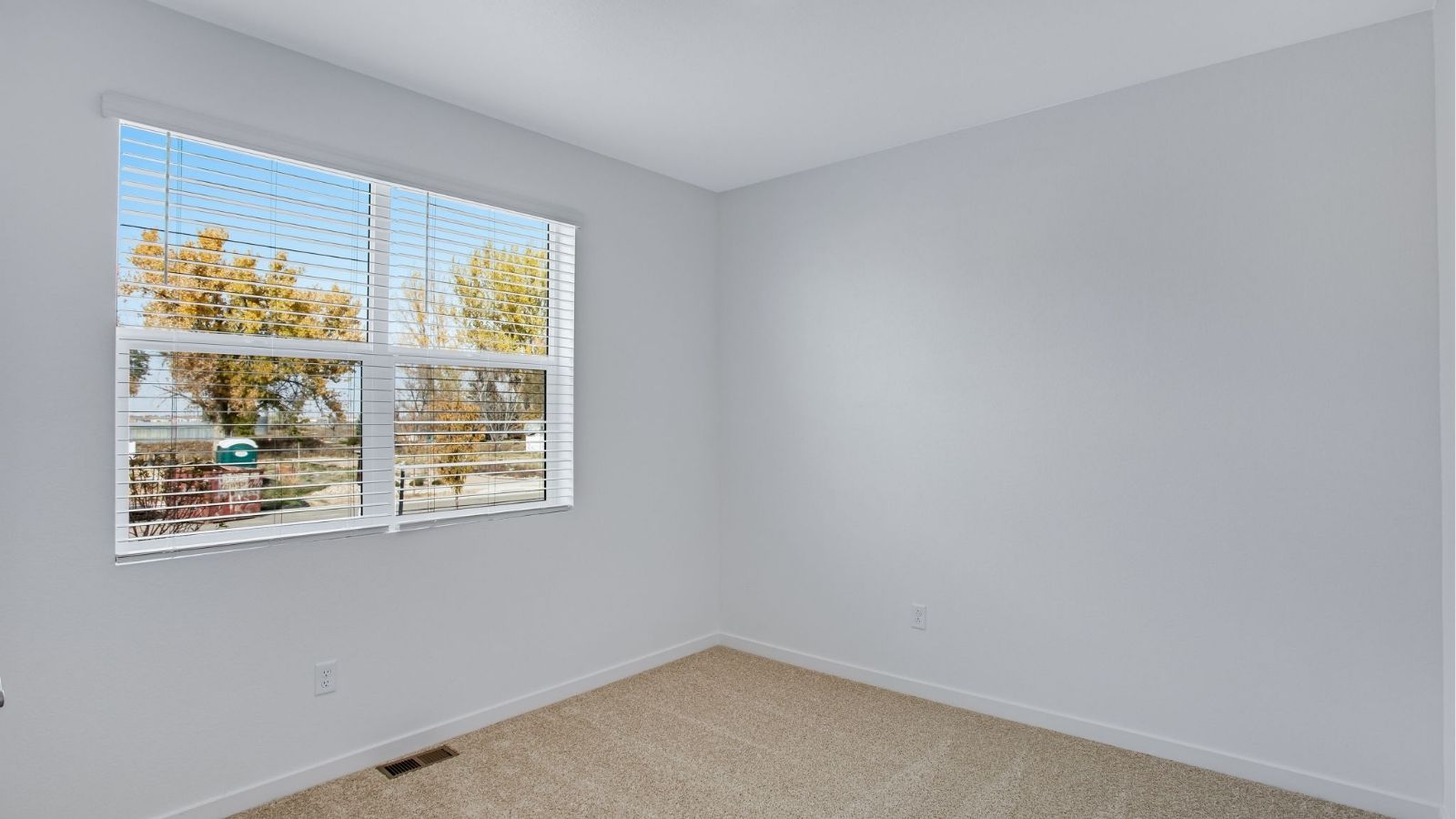 Comfortable secondary bedroom in the Newcastle floor plan ideal for family, guests, or a home office.