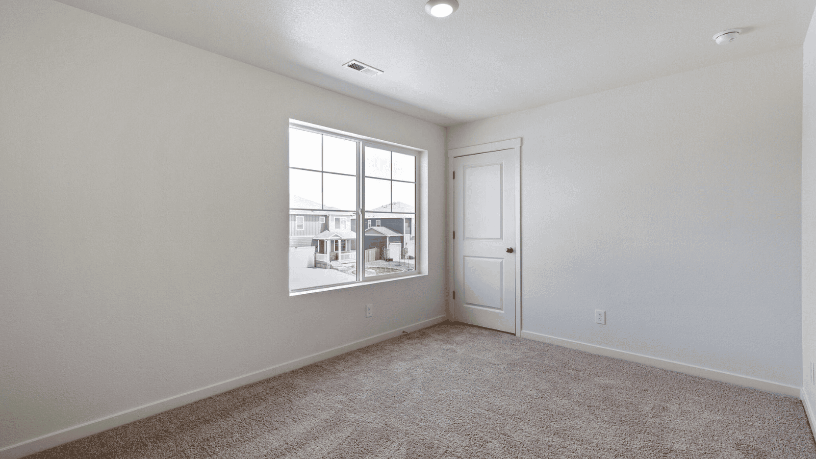 Comfortable secondary bedroom in the Sienna floor plan with a walk-in closet and versatile living space.