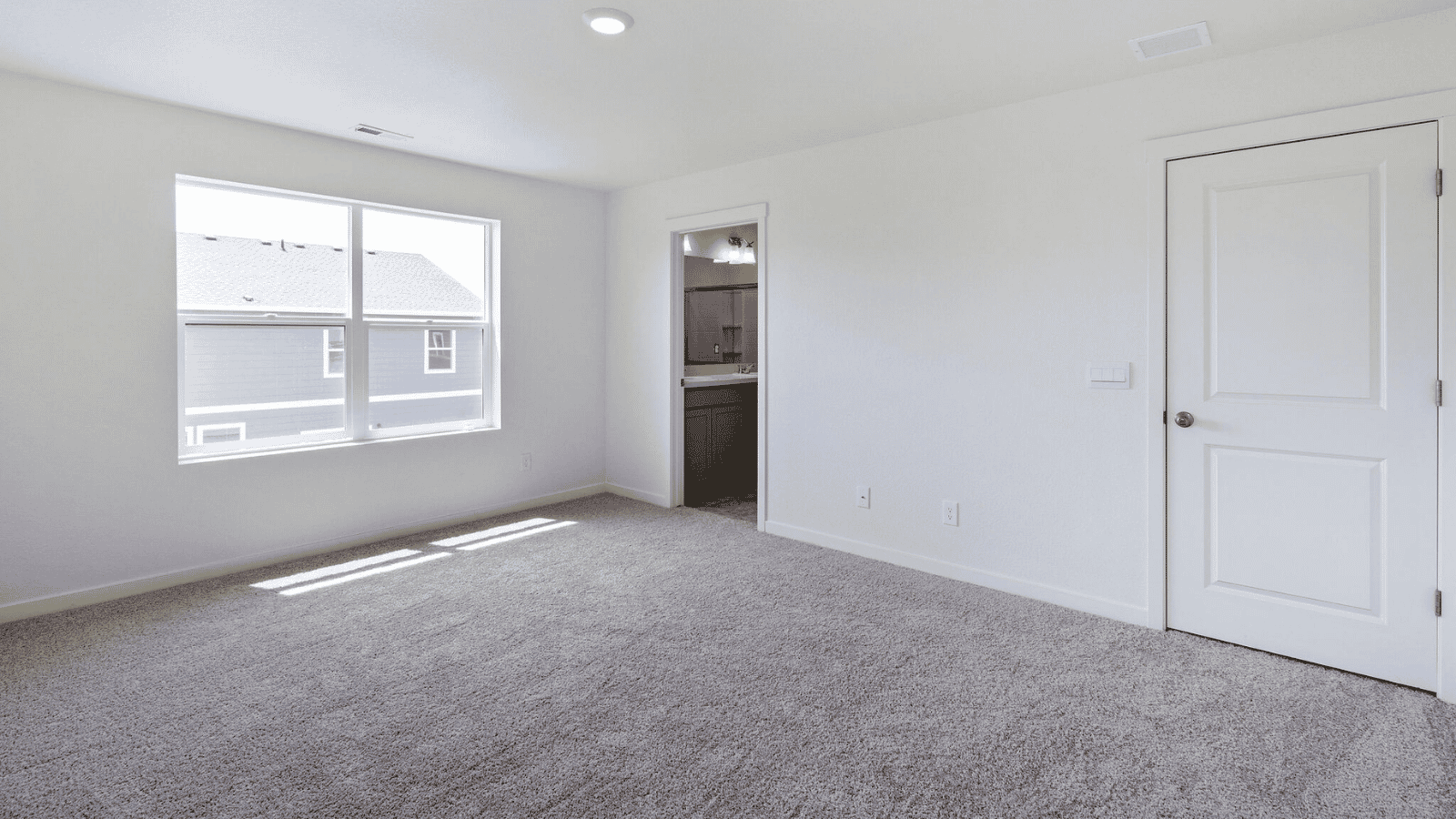 Spacious primary suite in the Sienna home featuring a walk-in closet and private ensuite bathroom.