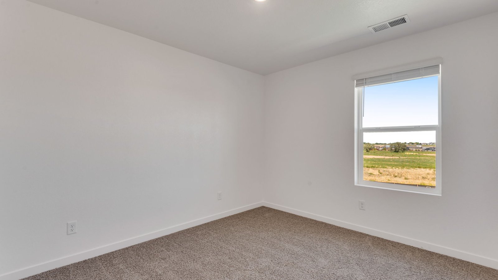 Bright guest bedroom with versatile space for family, guests, or a home office.