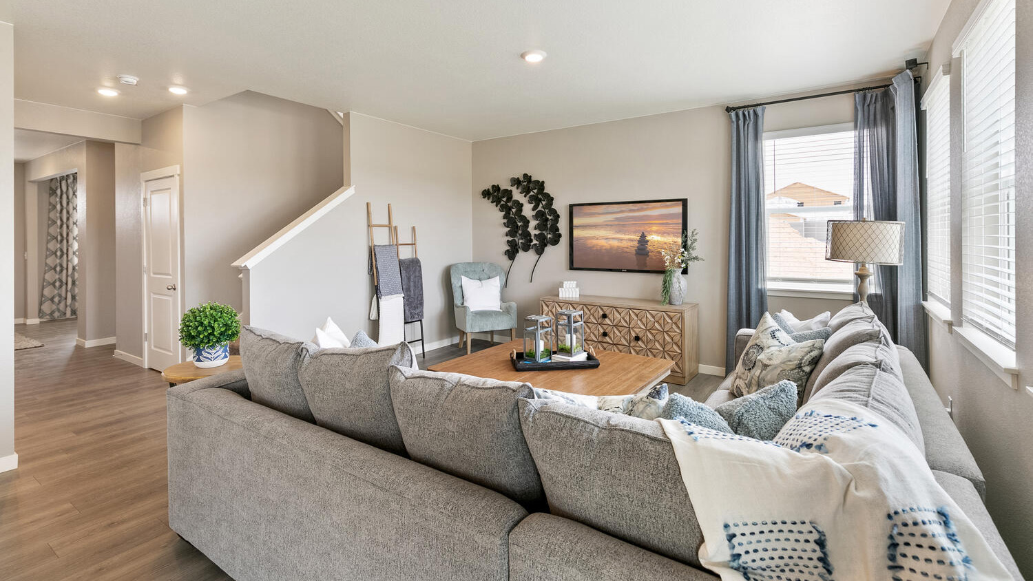 Modern kitchen featuring grey cabinets, stainless steel appliances, a large eat-in island, and a walk-in pantry.