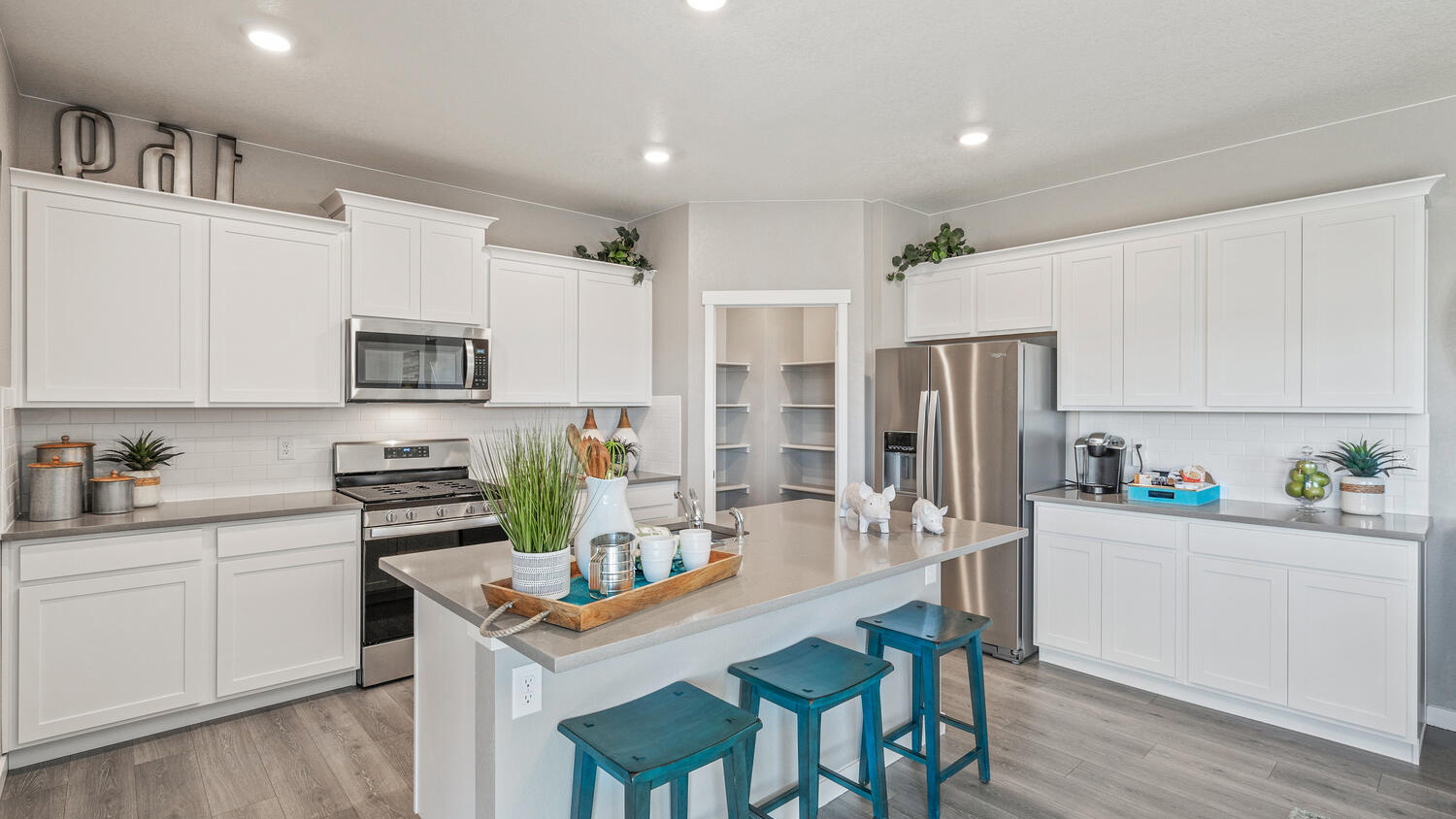 Modern kitchen with white cabinetry in new D.R. Horton home in Greeley, CO