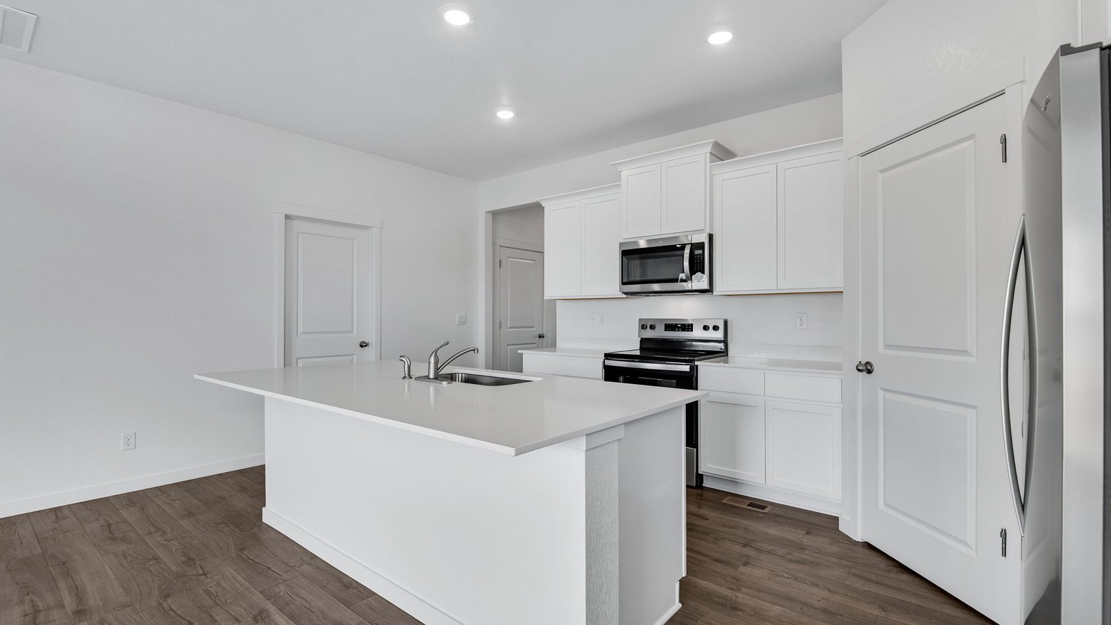 kitchen with large island in new fort lupton home