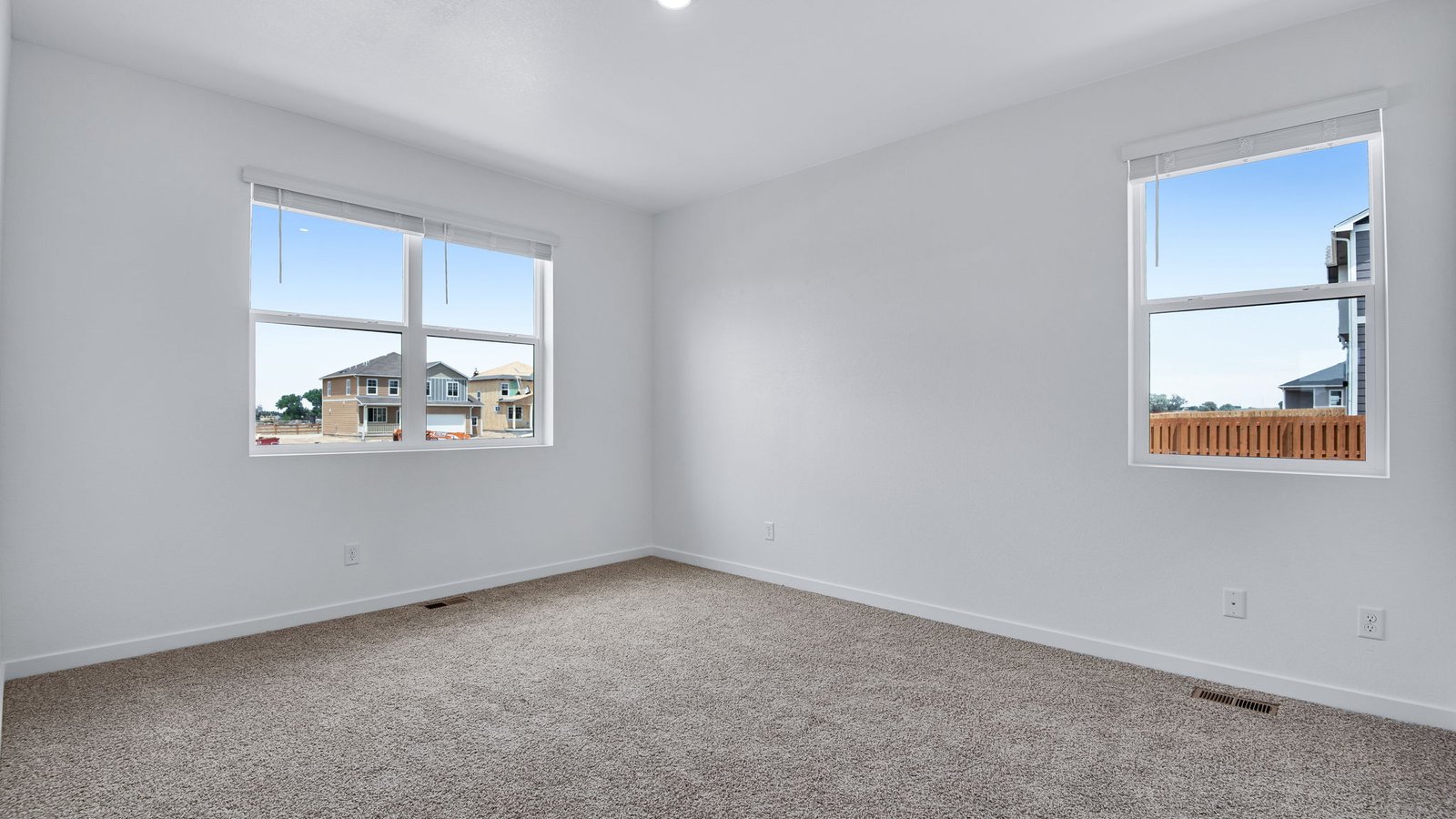 Primary bedroom with large windows in Fort Lupton Colorado home Chatham floorplan