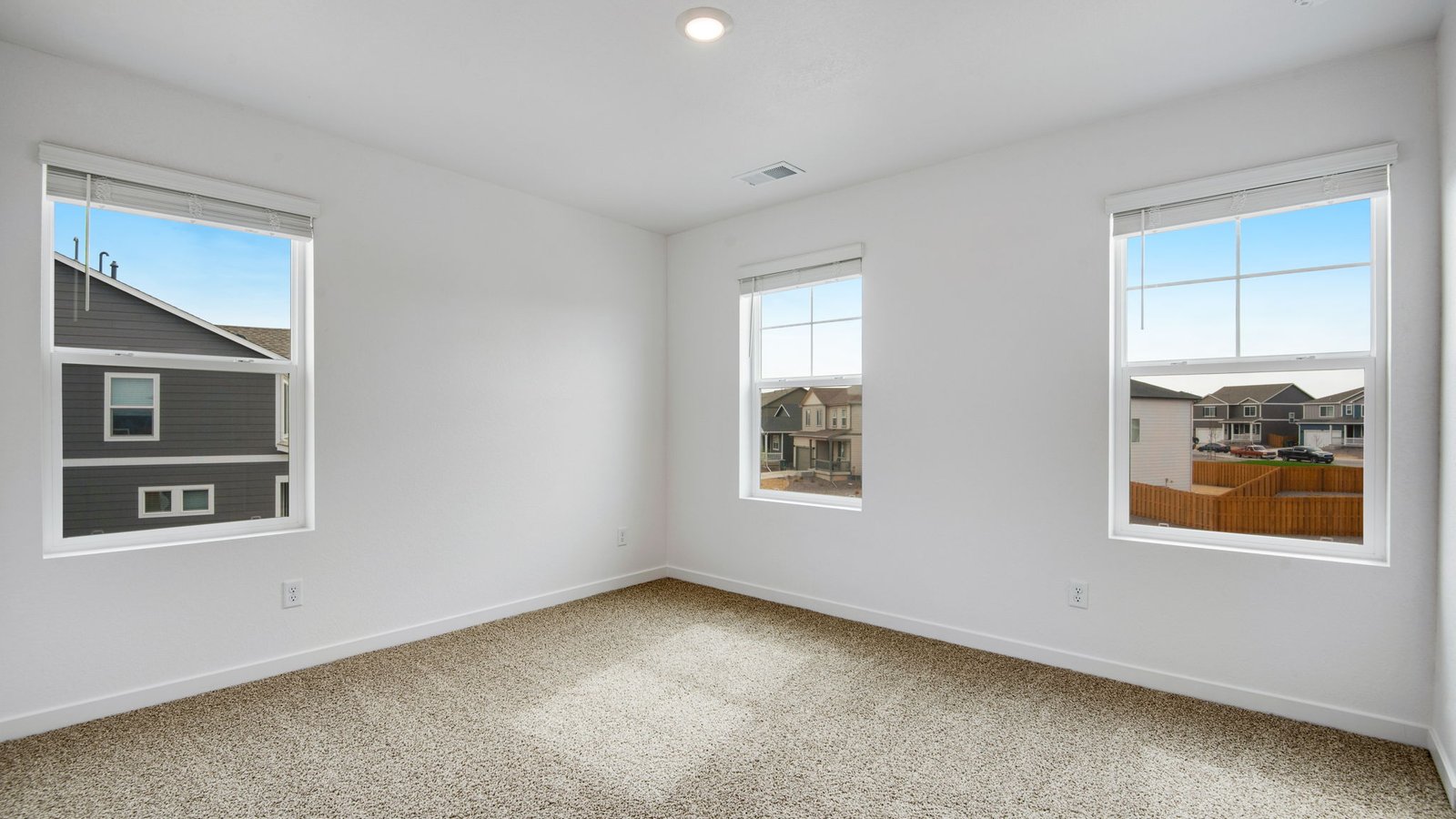 Secondary bedroom with large windows in new D.R. Horton home in Fort Lupton, Colorado