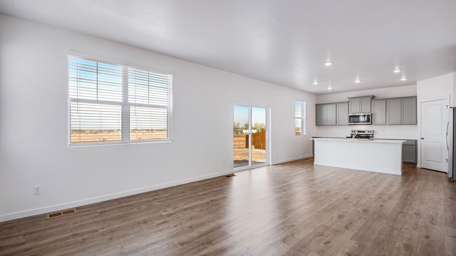 Open concept living room space with large windows and natural light in Fort Lupton, Colorado