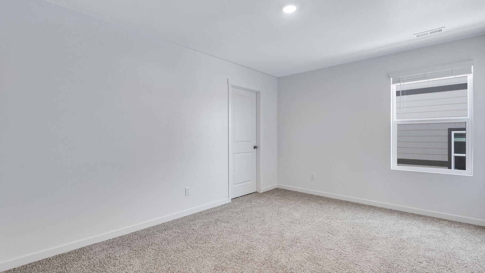 Secondary bedroom with large windows in new D.R. Horton home