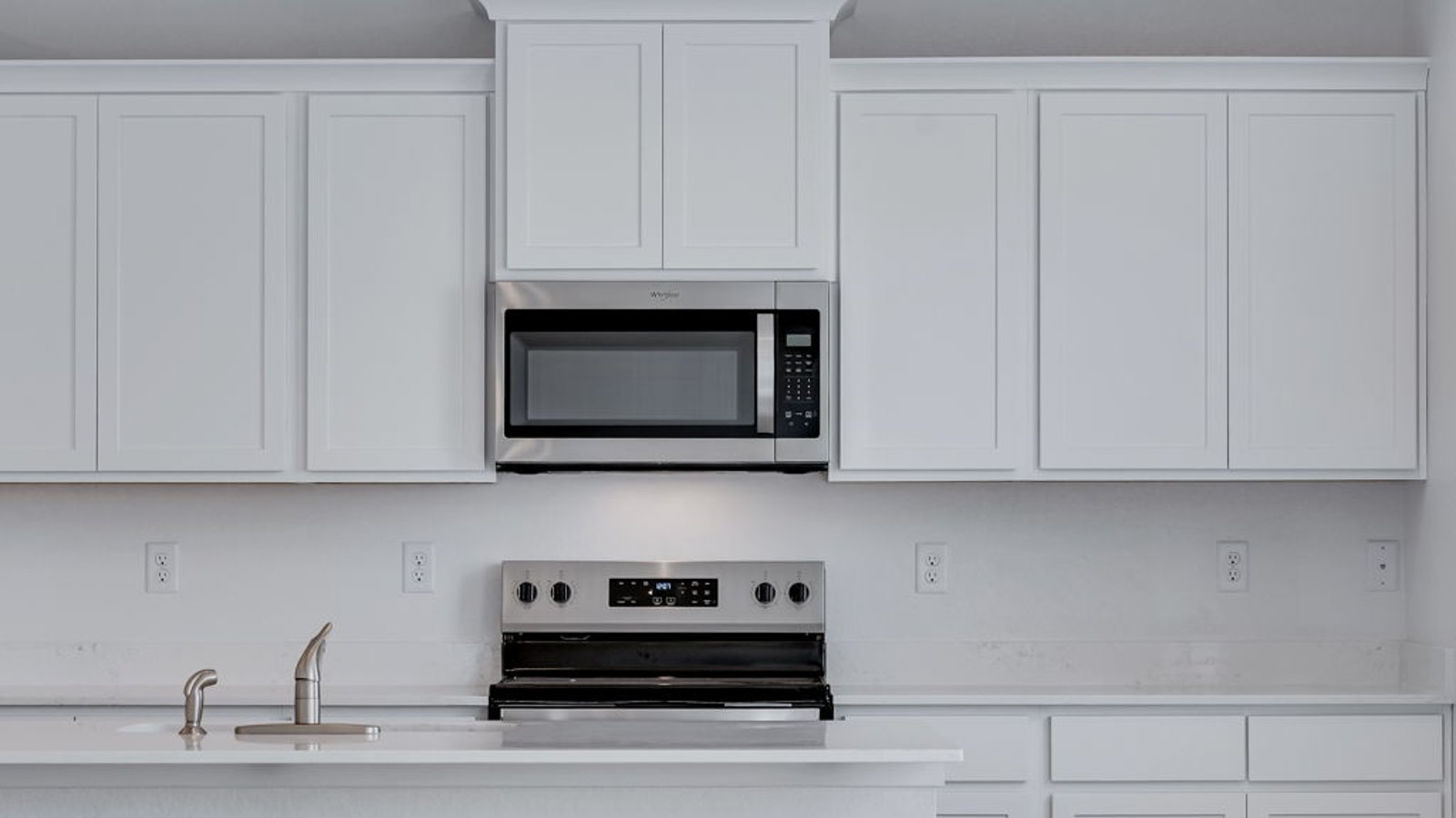 Modern kitchen with white cabinets, quartz countertops, and a spacious island with seating