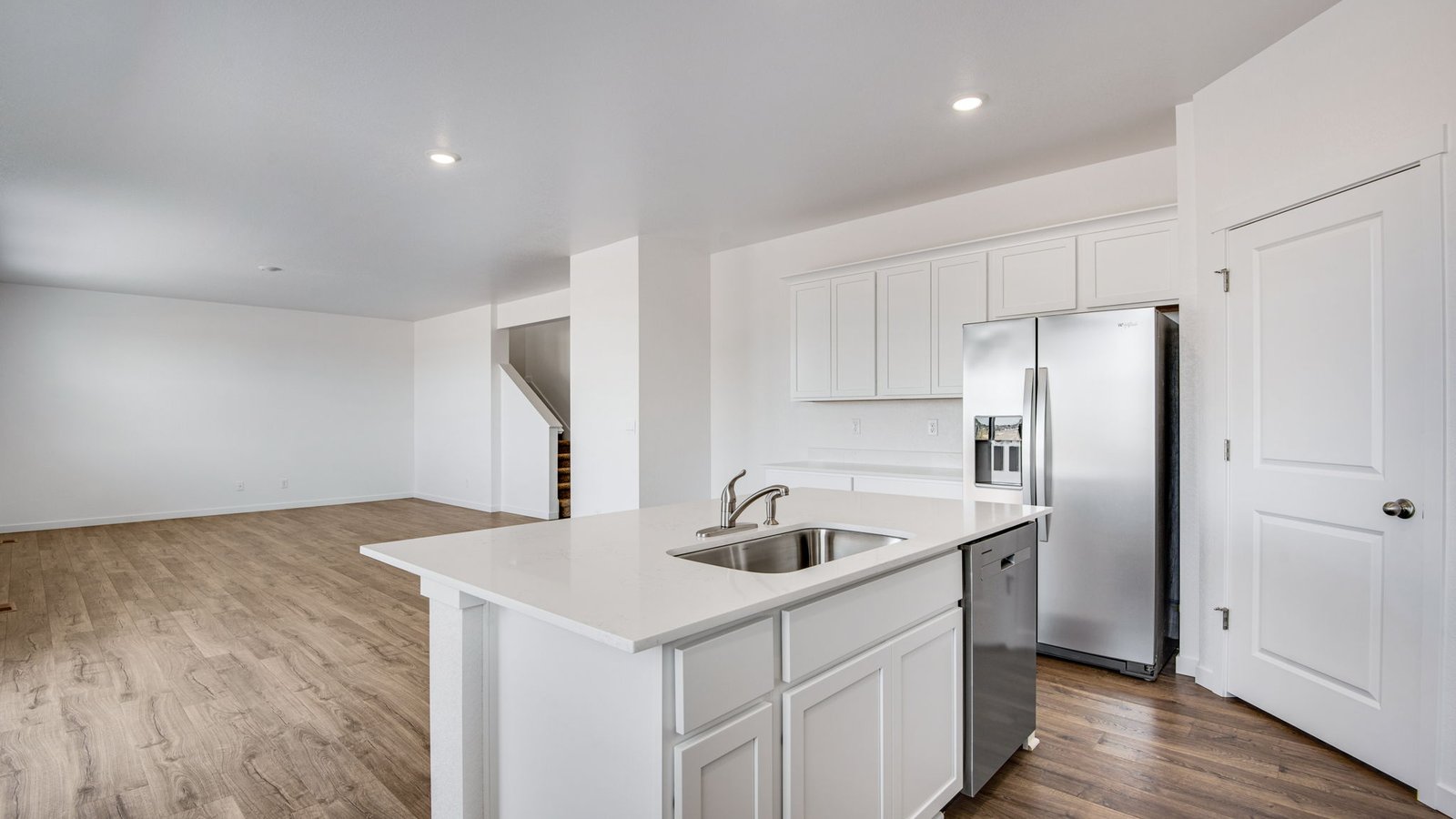 view from kitchen into dining and living room in new fort lupton home