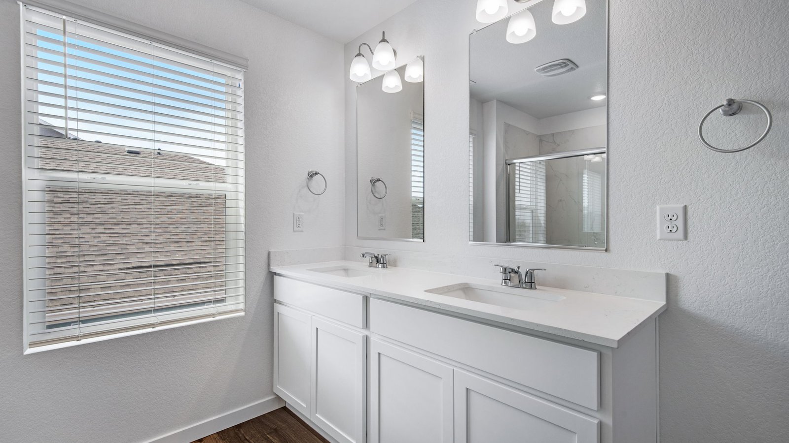 primary bath with dual sinks in new fort lupton home