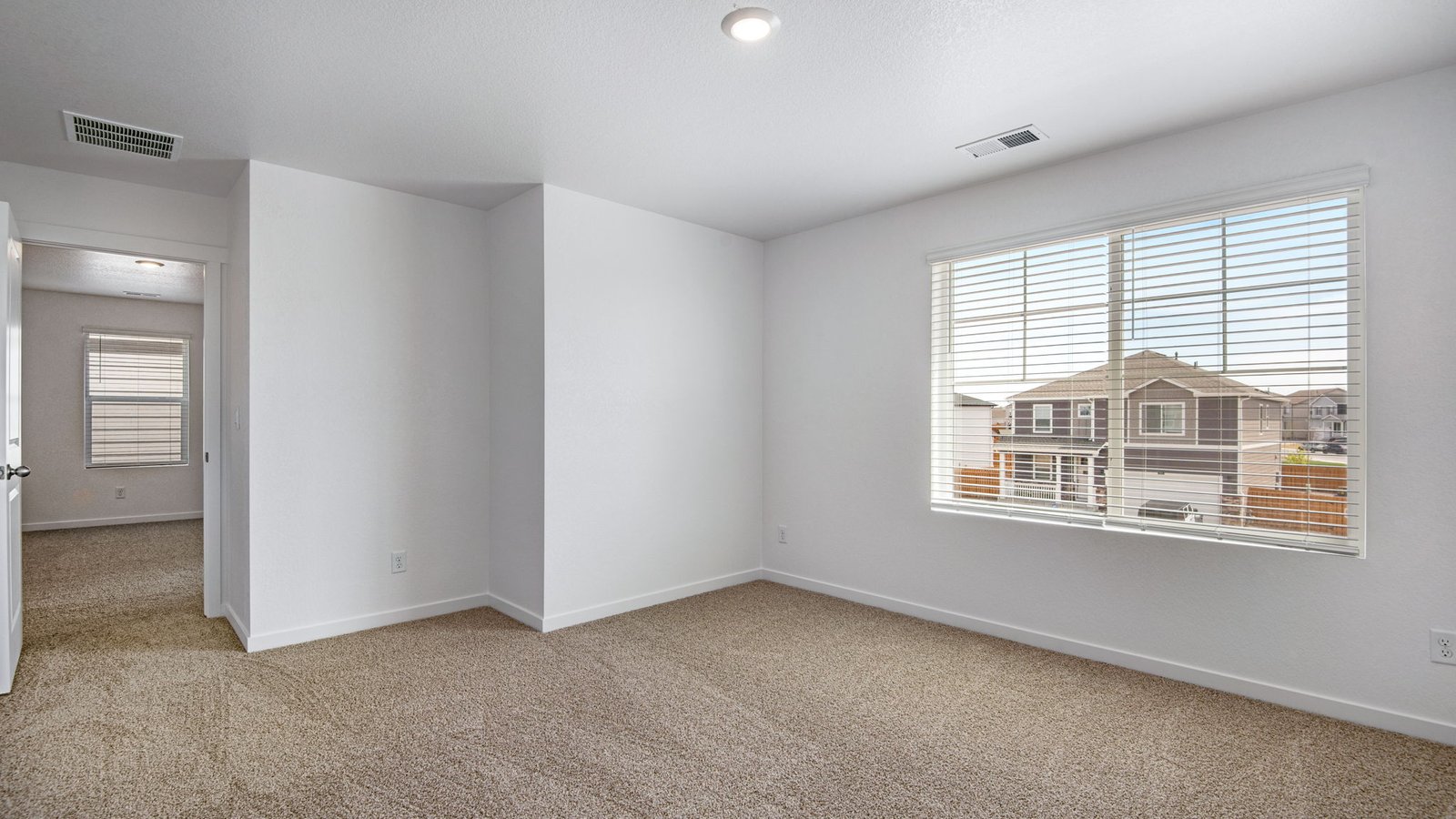 secondary bedroom with large window in new construction home by d.r. horton