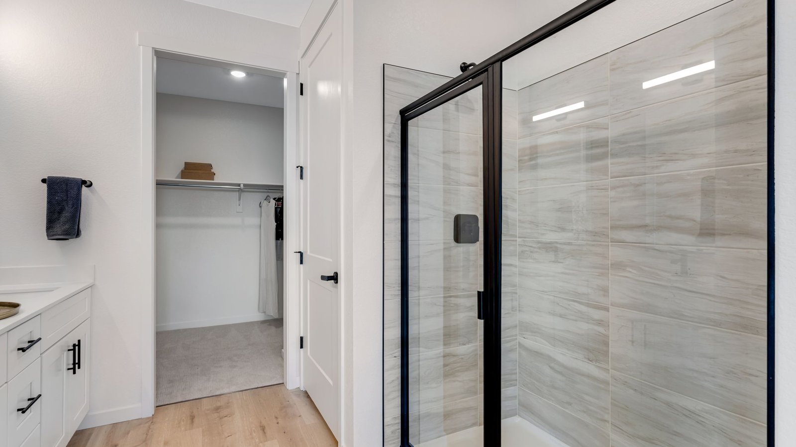 Primary bathroom featuring double vanity, walk-in shower, and contemporary finishes.