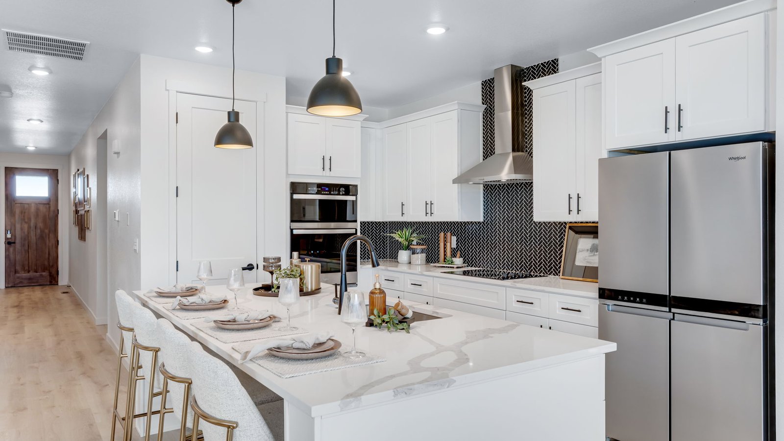 Bright open-concept kitchen with oversized center island, modern cabinetry, and stainless steel appliances.
