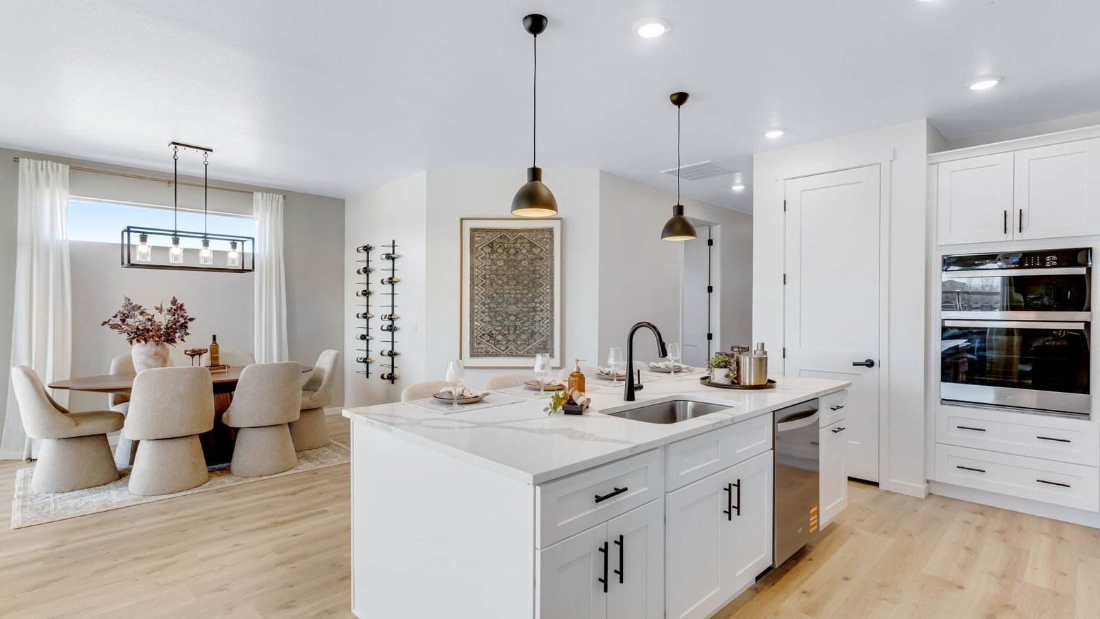 Contemporary kitchen with quartz-style countertops, pendant lighting, and open sightlines to the dining room.