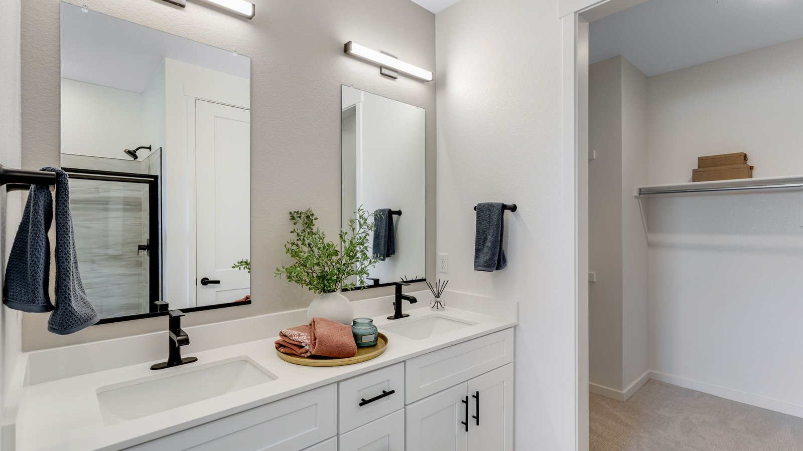 Owner's bathroom with dual-sink vanity, walk-in shower, and convenient access to the walk-in closet.