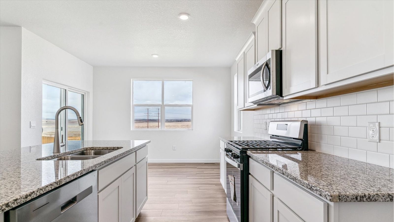 Dining nook with natural light and backyard views in a new two‑story home in Johnstown, CO.