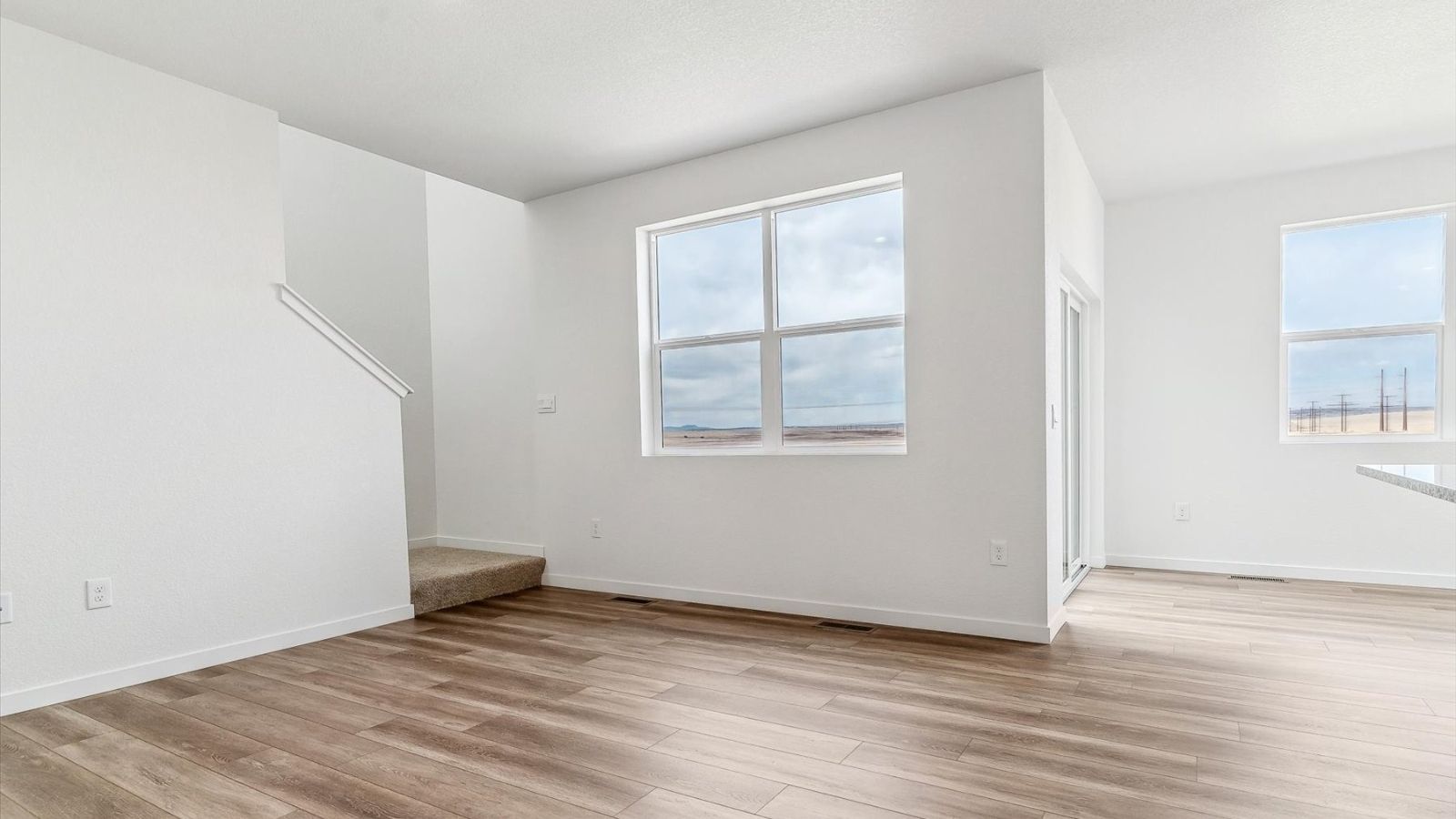 Open living room connected to kitchen and dining area in the Cabral floorplan at The Ridge at Johnstown.