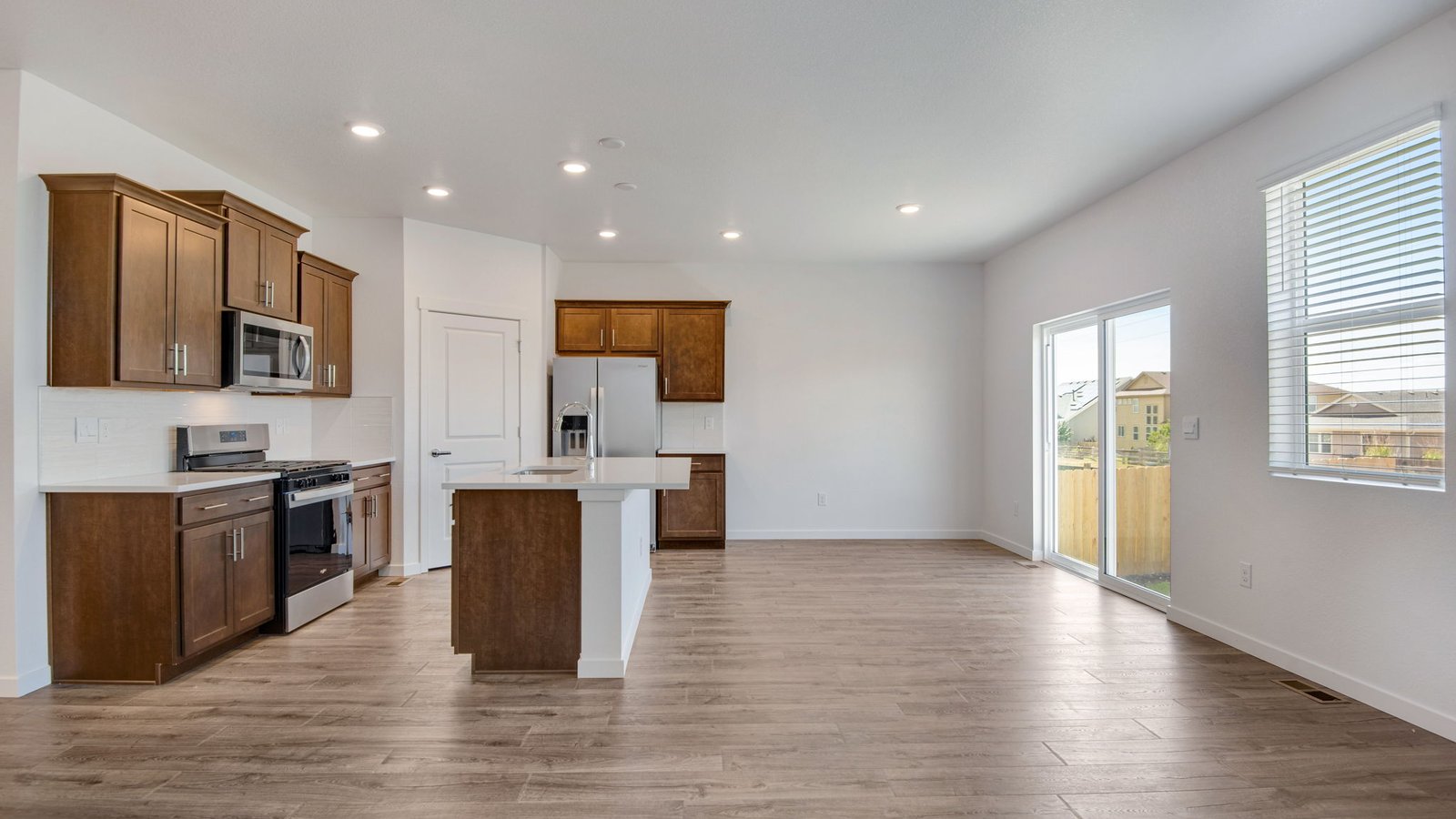 Spacious great room in the Harmony floor plan featuring an open-concept layout, abundant natural light, modern finishes, and seamless connection to the kitchen and dining area.