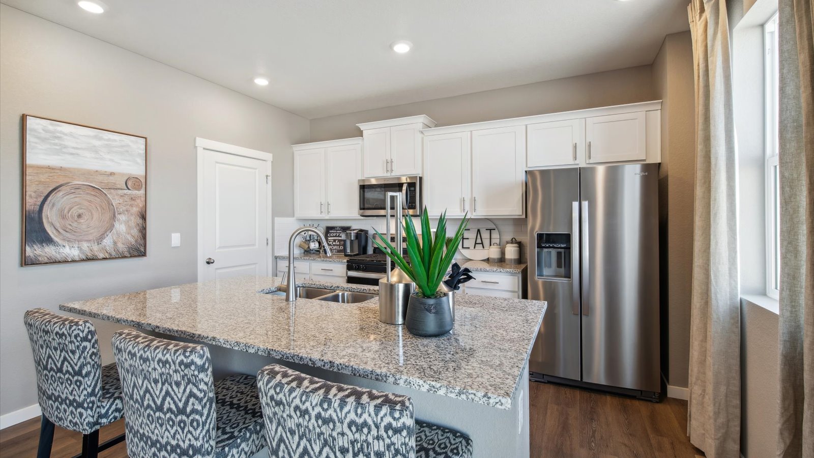 Chef-inspired kitchen in the Pendleton featuring white cabinetry, a large center island, and walk-in pantry.