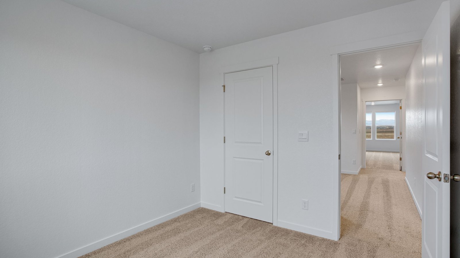 Bright secondary bedroom featuring natural light and flexible space for family or guests.