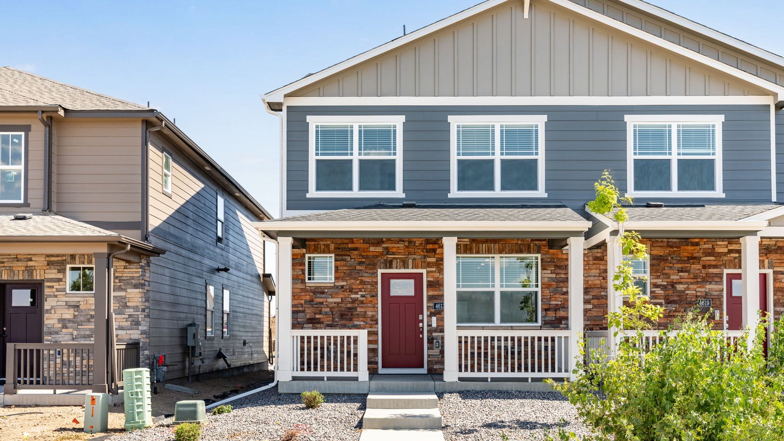 Melbourne paired home in Revere at Johnstown featuring modern architecture, attractive curb appeal, and landscaped front yard.
