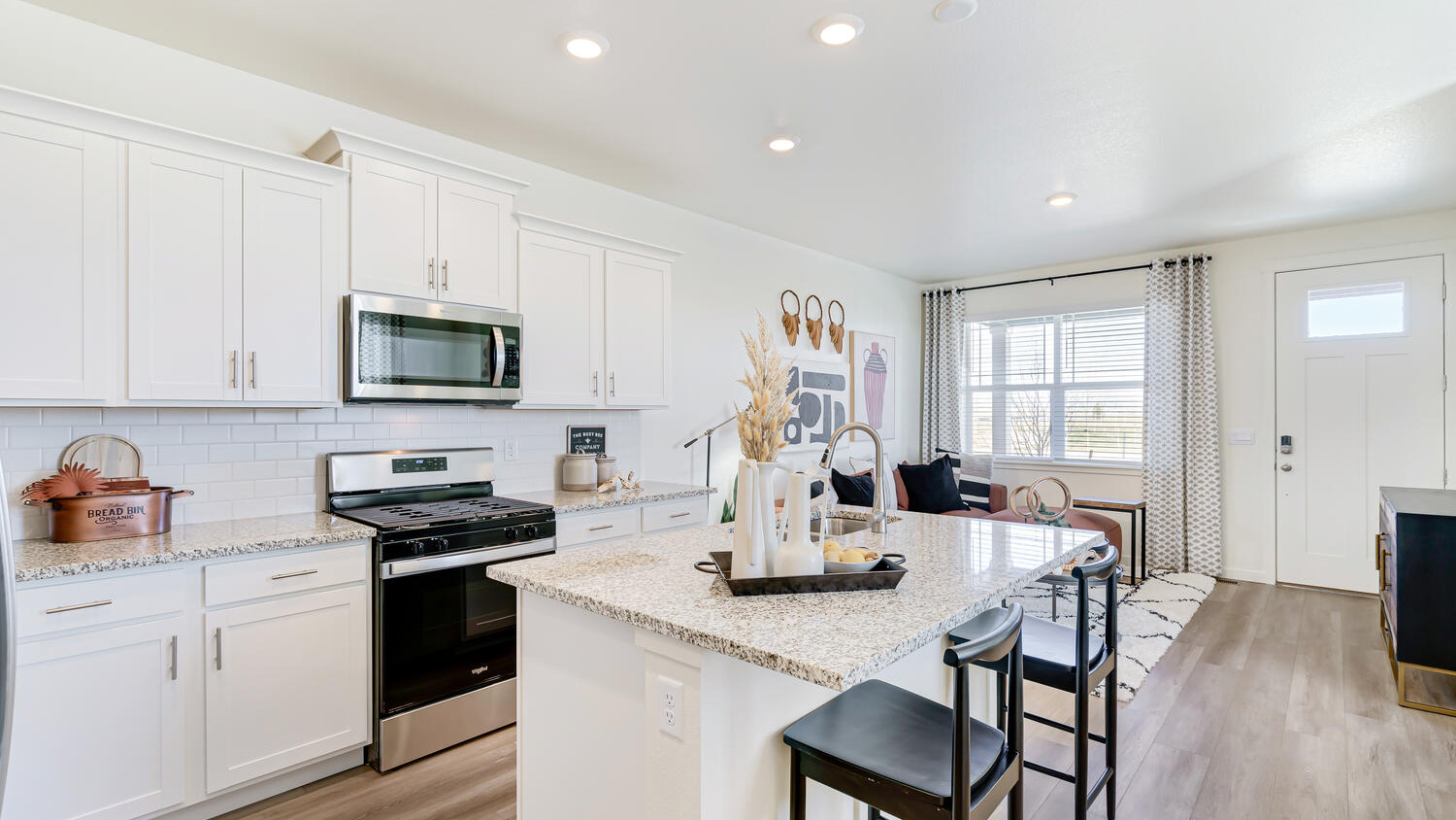 Large quartz kitchen island with seating, providing additional prep space and casual dining options.