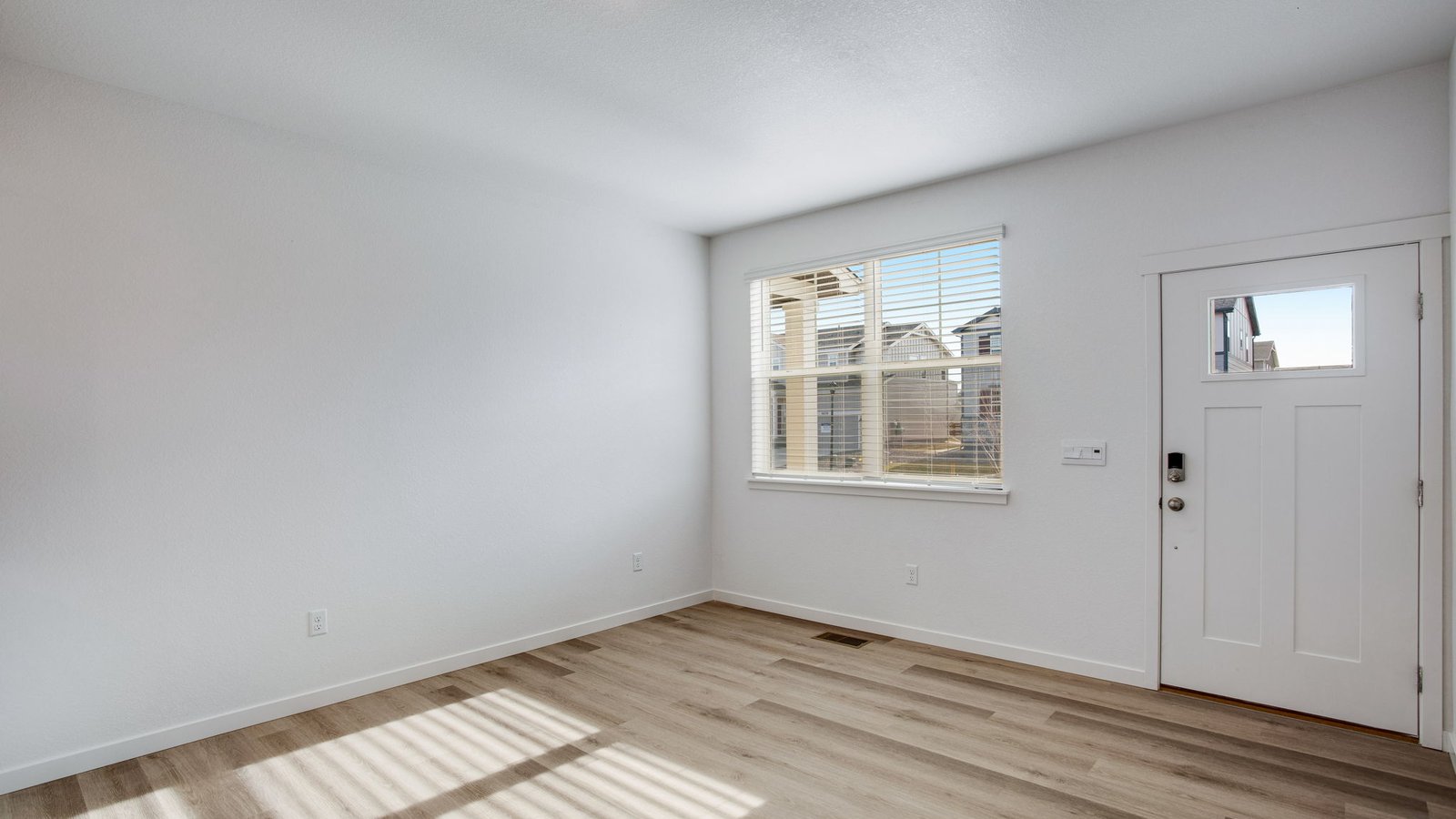 living room with large window in new construction home by d.r. horton johnstown, co