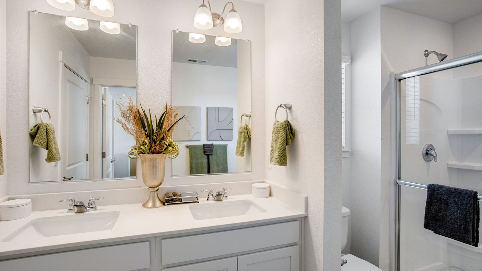 Modern primary bathroom in the Muirfield home featuring dual sinks and contemporary finishes.