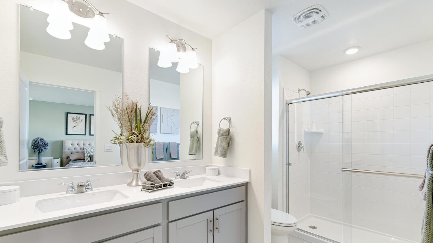 Modern primary bathroom in the Muirfield home featuring dual sinks and contemporary finishes.