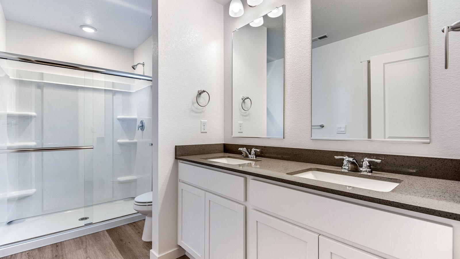 Primary bathroom with white cabinets and quartz countertops