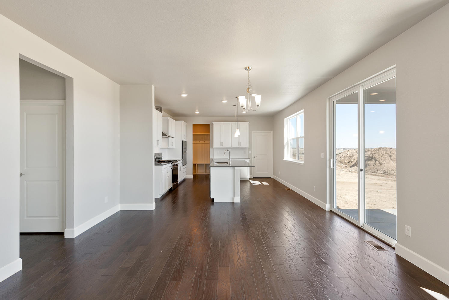 dining room and kitchen with wood floor, a window and back door