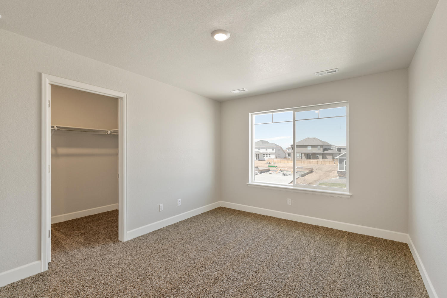 bedroom with a window, carpet floor, and a closet