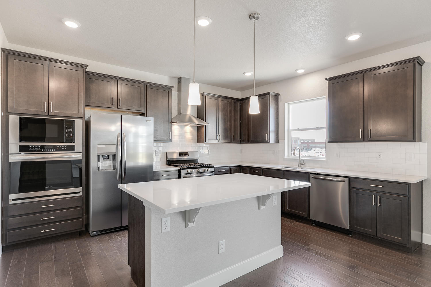 brown cabinet kitchen with an island  and stainless steel appliances