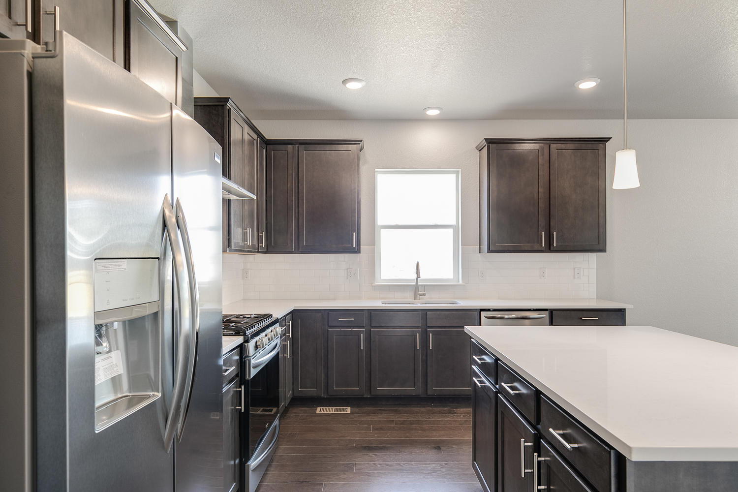 brown cabinet kitchen with an island  and stainless steel appliances