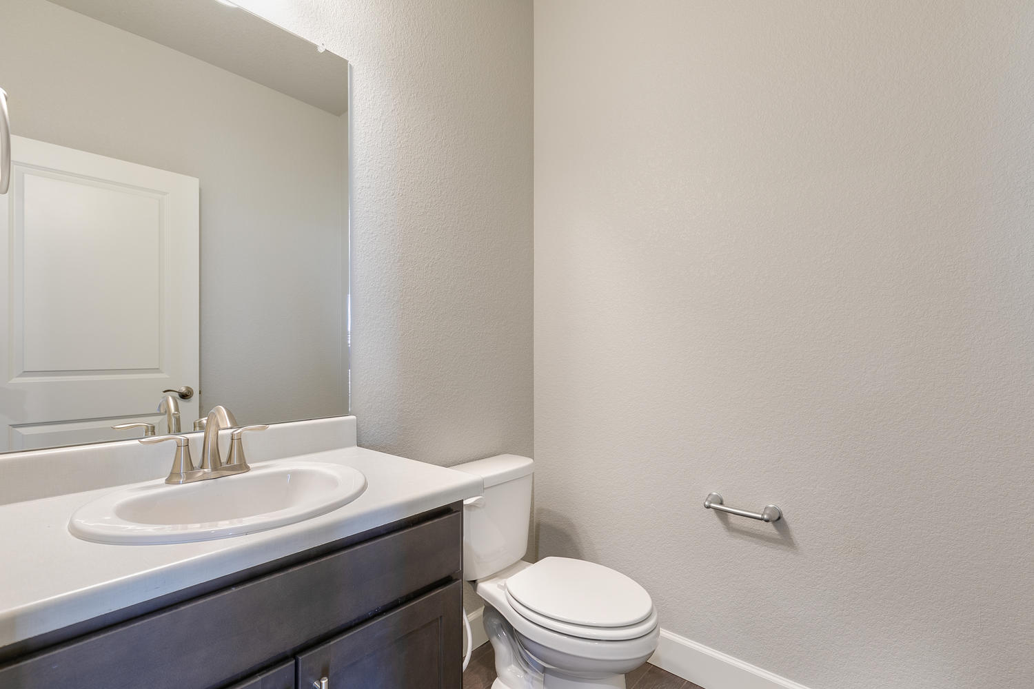 brown cabinet bathroom with a toilet and sink