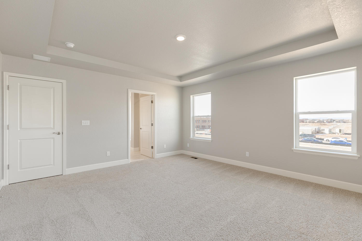 bedroom with two windows, crown molding ceiling, and door to bathroom
