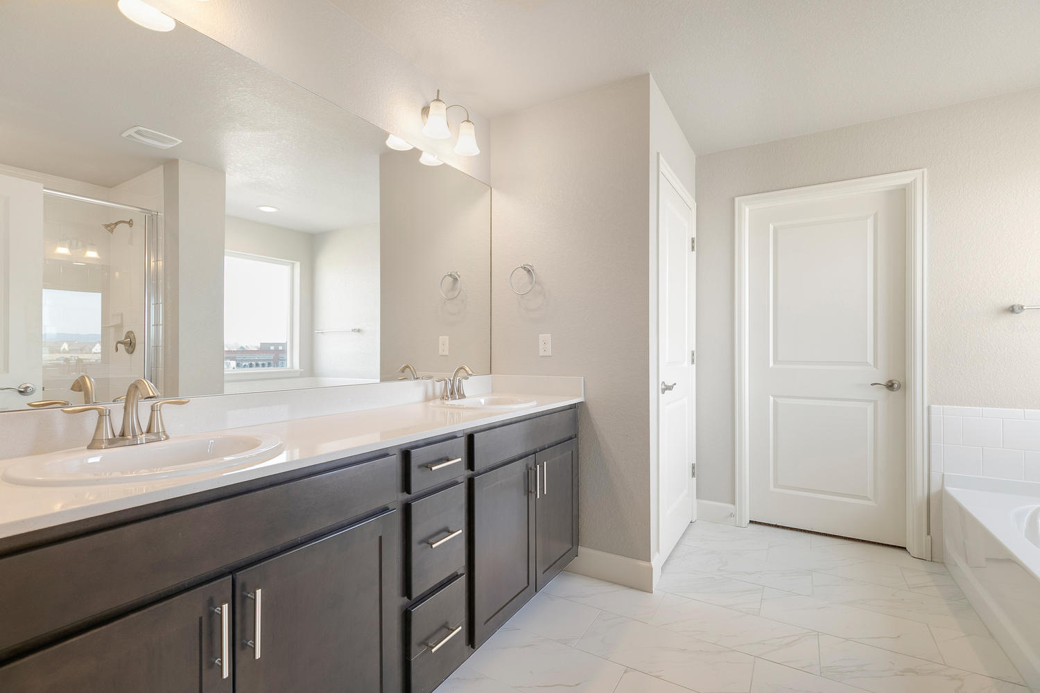 brown cabinet bathroom with a tub and dual-basin sink