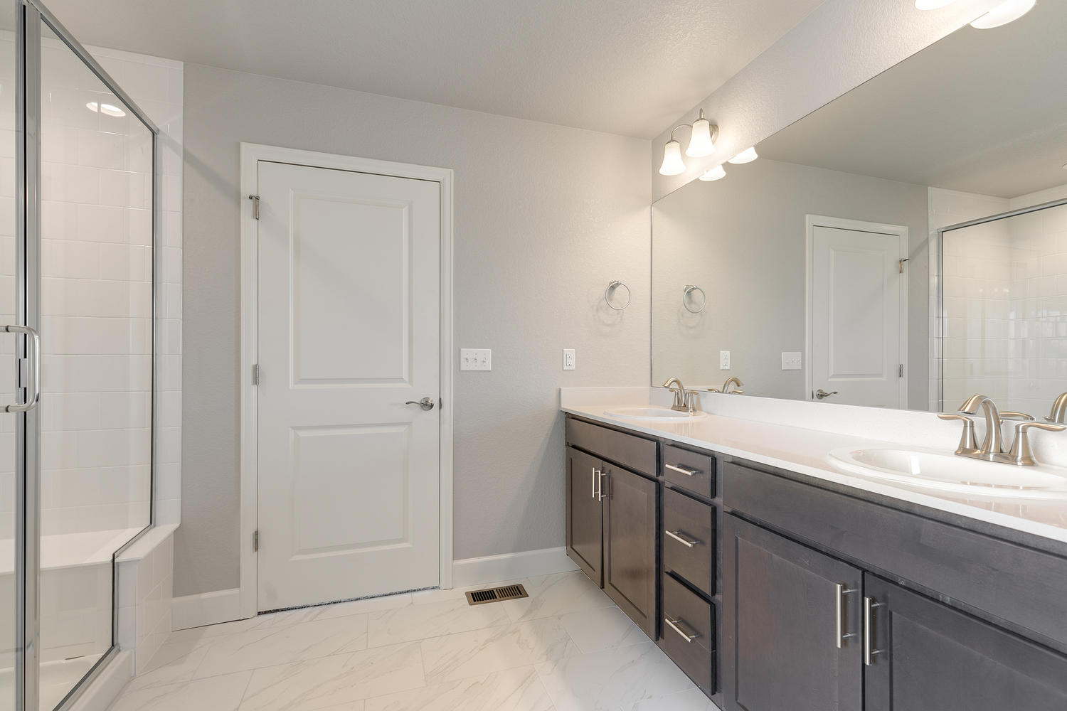 brown cabinet bathroom with a shower and dual-basin sink