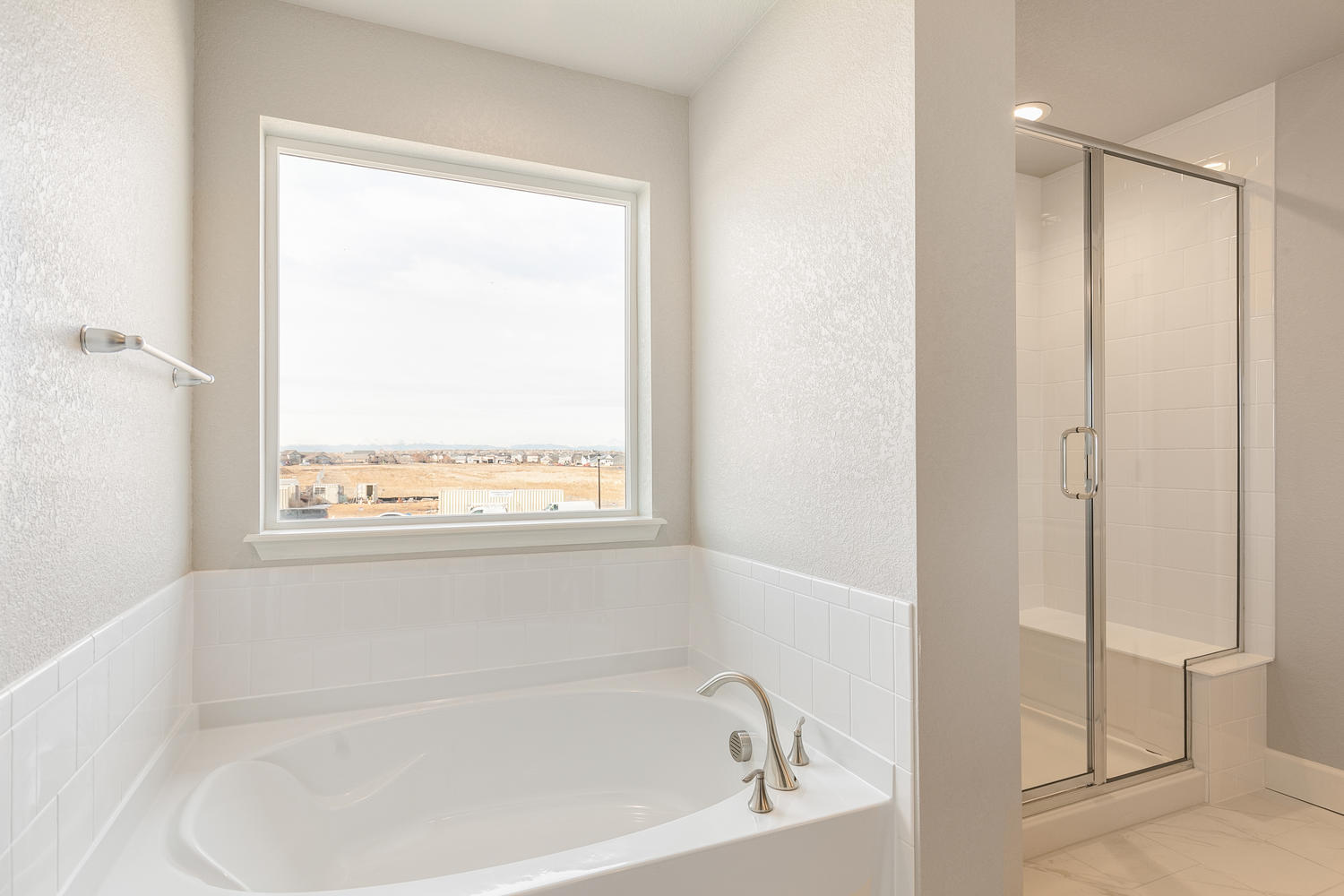 bathroom with a tub and shower with a window