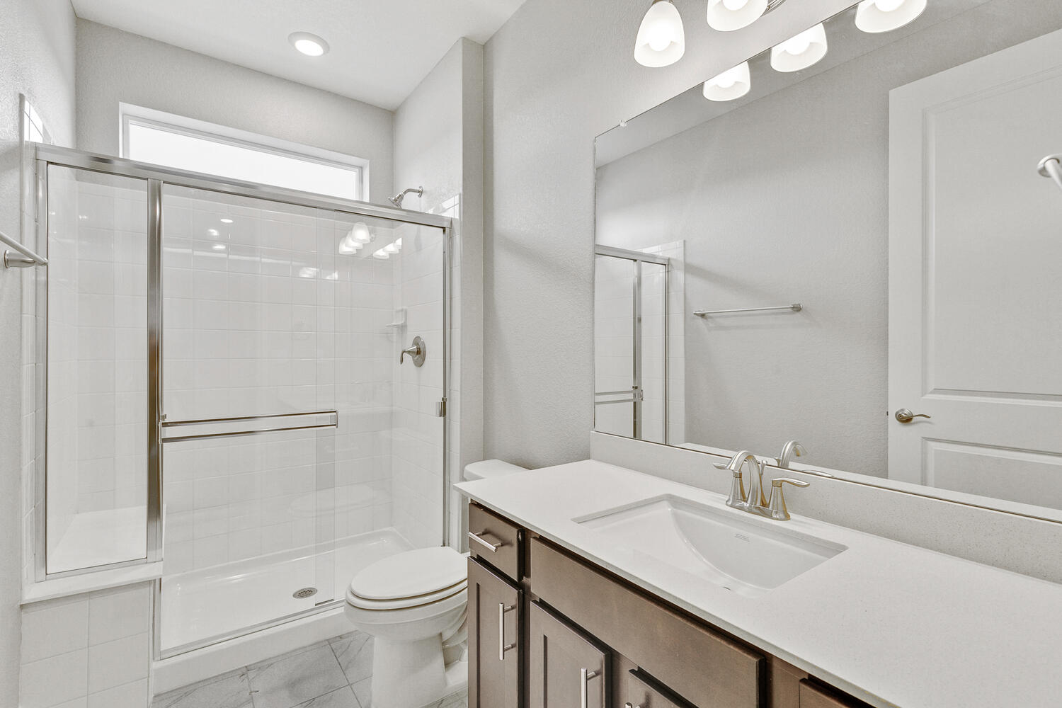brown cabinet bathroom with a shower and toilet