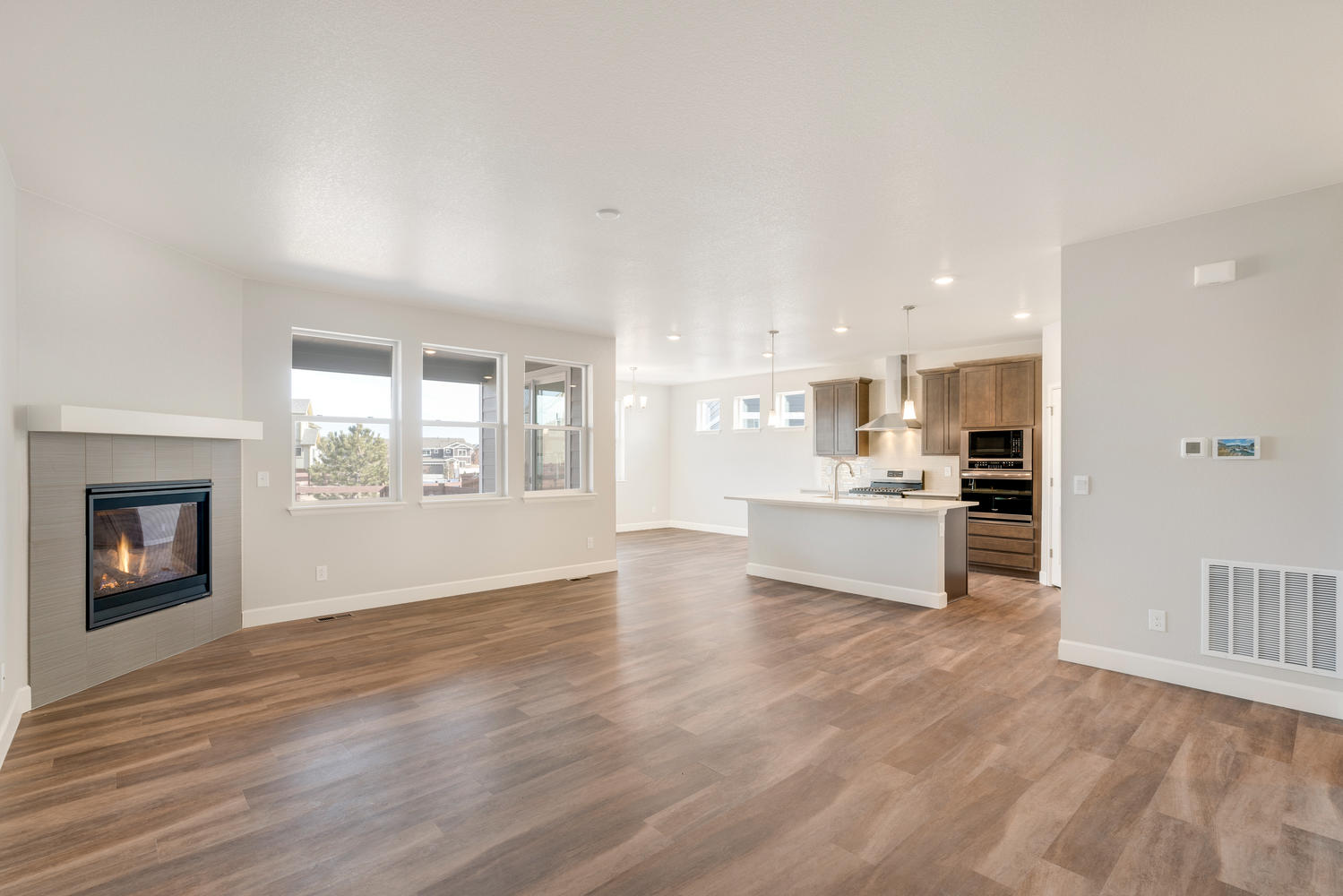 living room with fireplace, windows and kitchen view