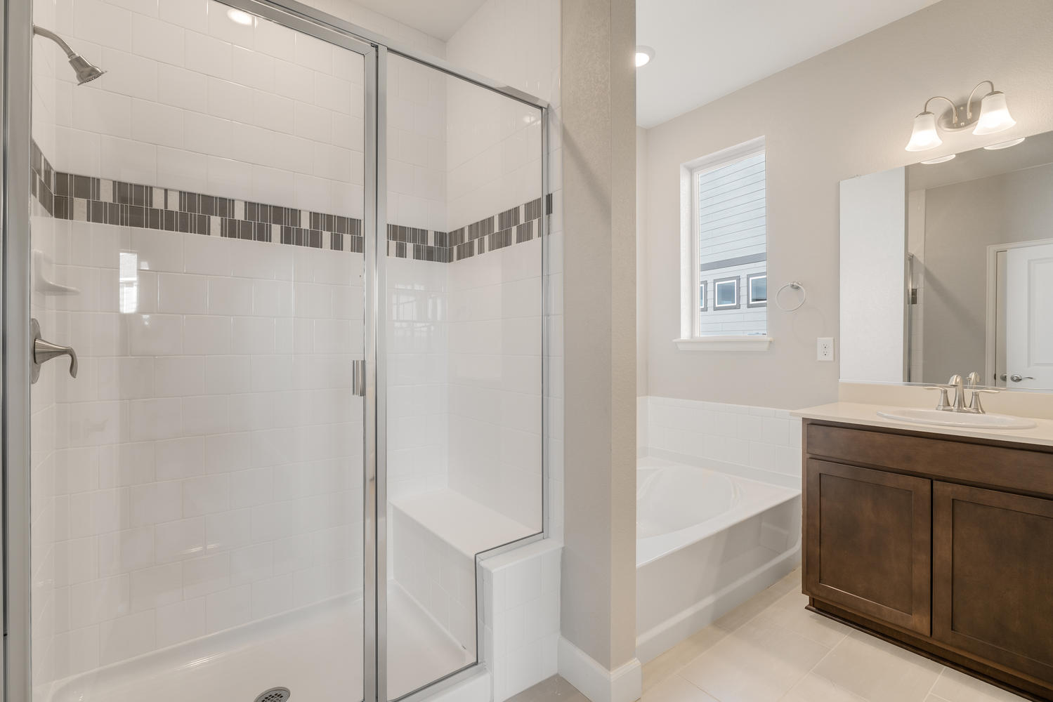 brown cabinet bathroom with dual-basin sink, shower and a tub
