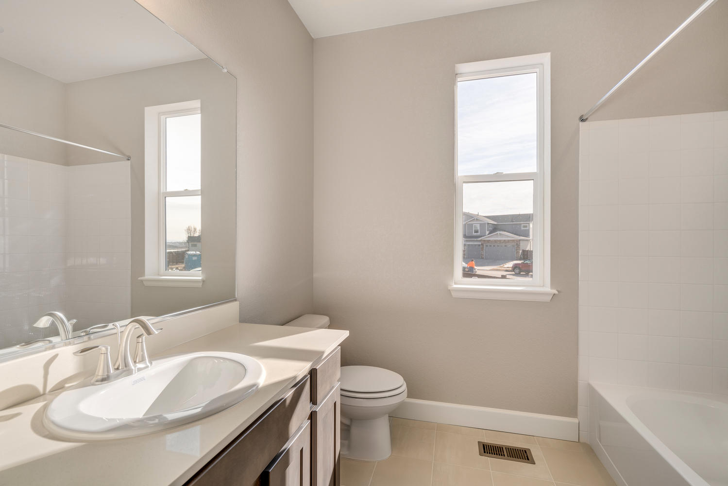 brown cabinet bathroom with a tub, window, and sink
