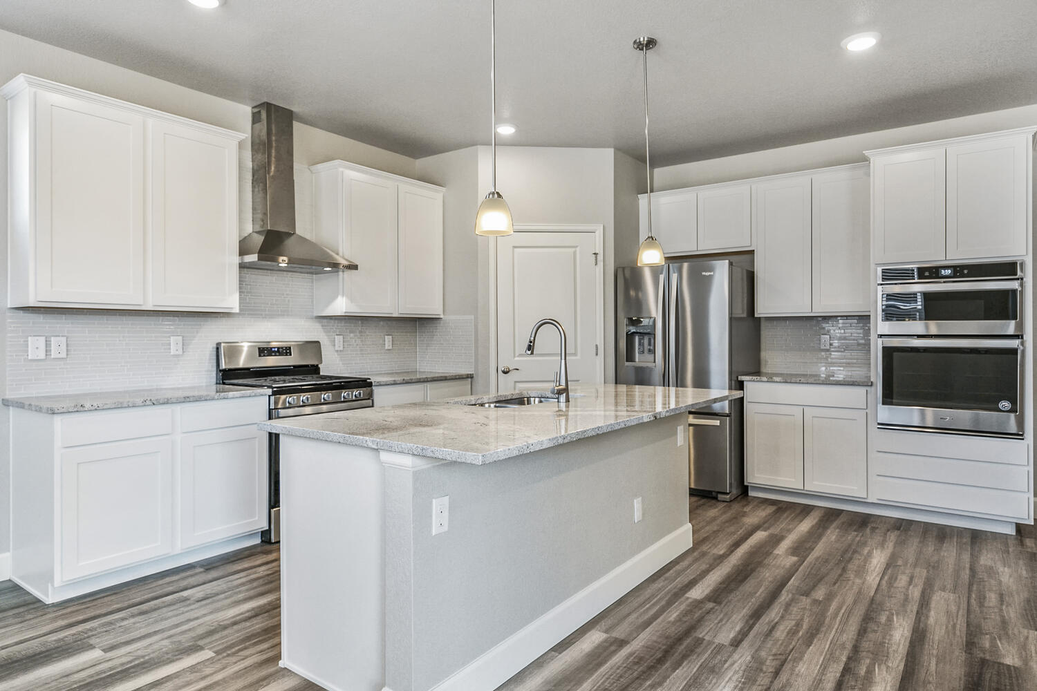 white cabinet kitchen with stainless steel appliances and an island