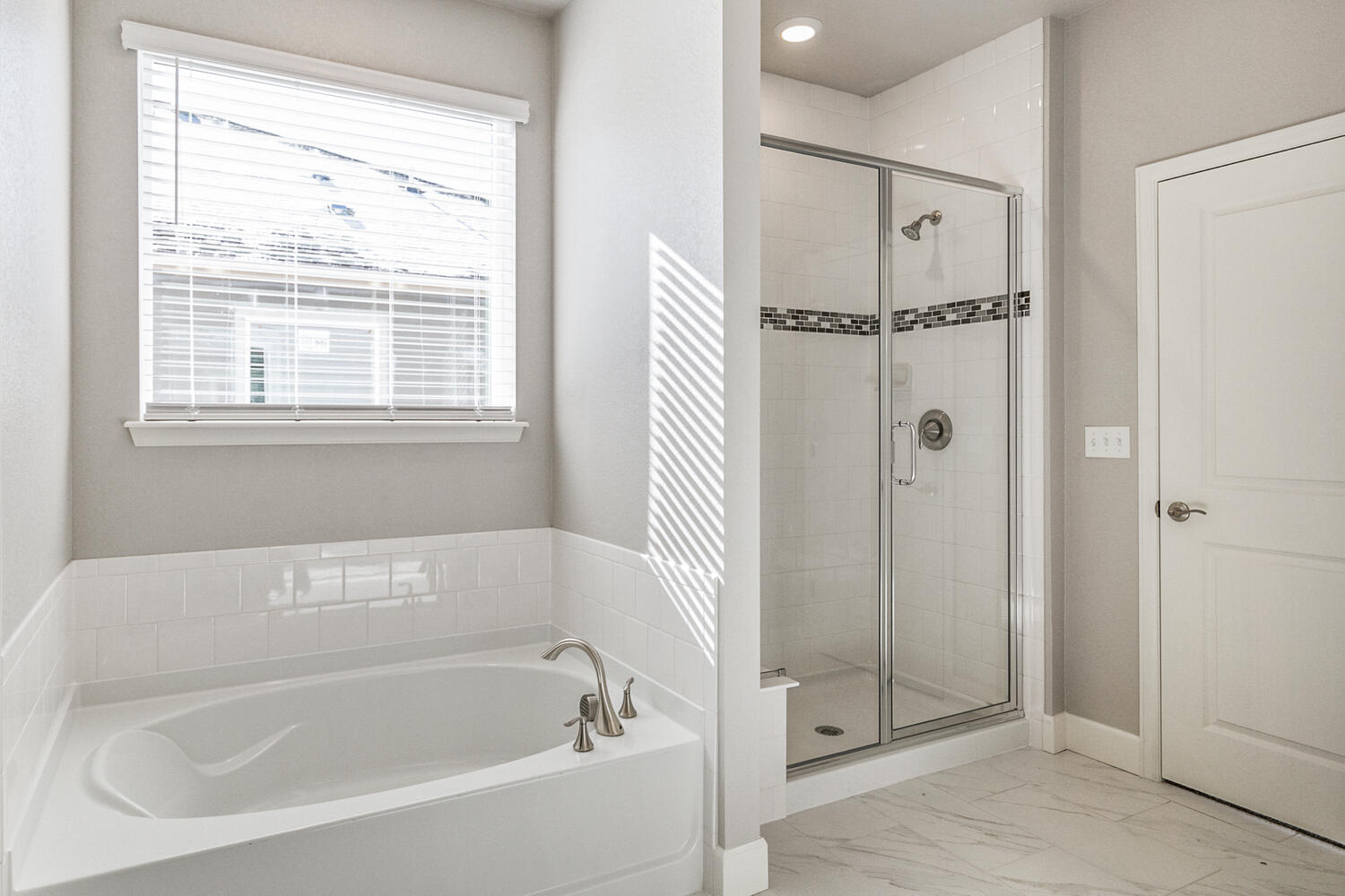 bathroom with a shower, window and tub