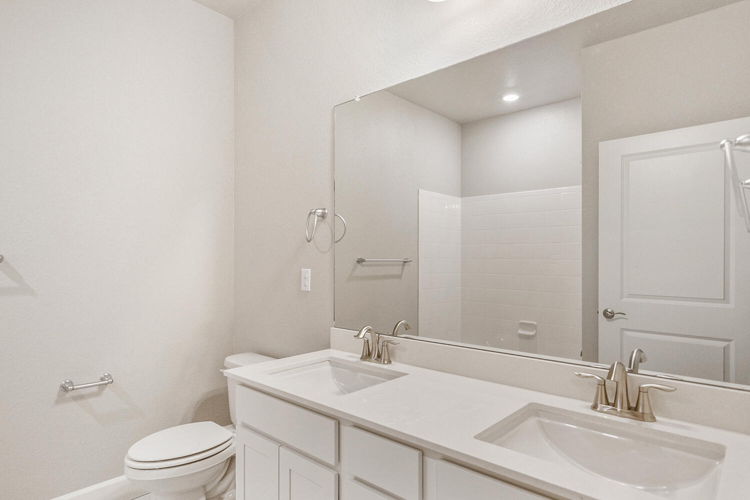 white cabinet bathroom with dual-basin sink, mirror and toilet